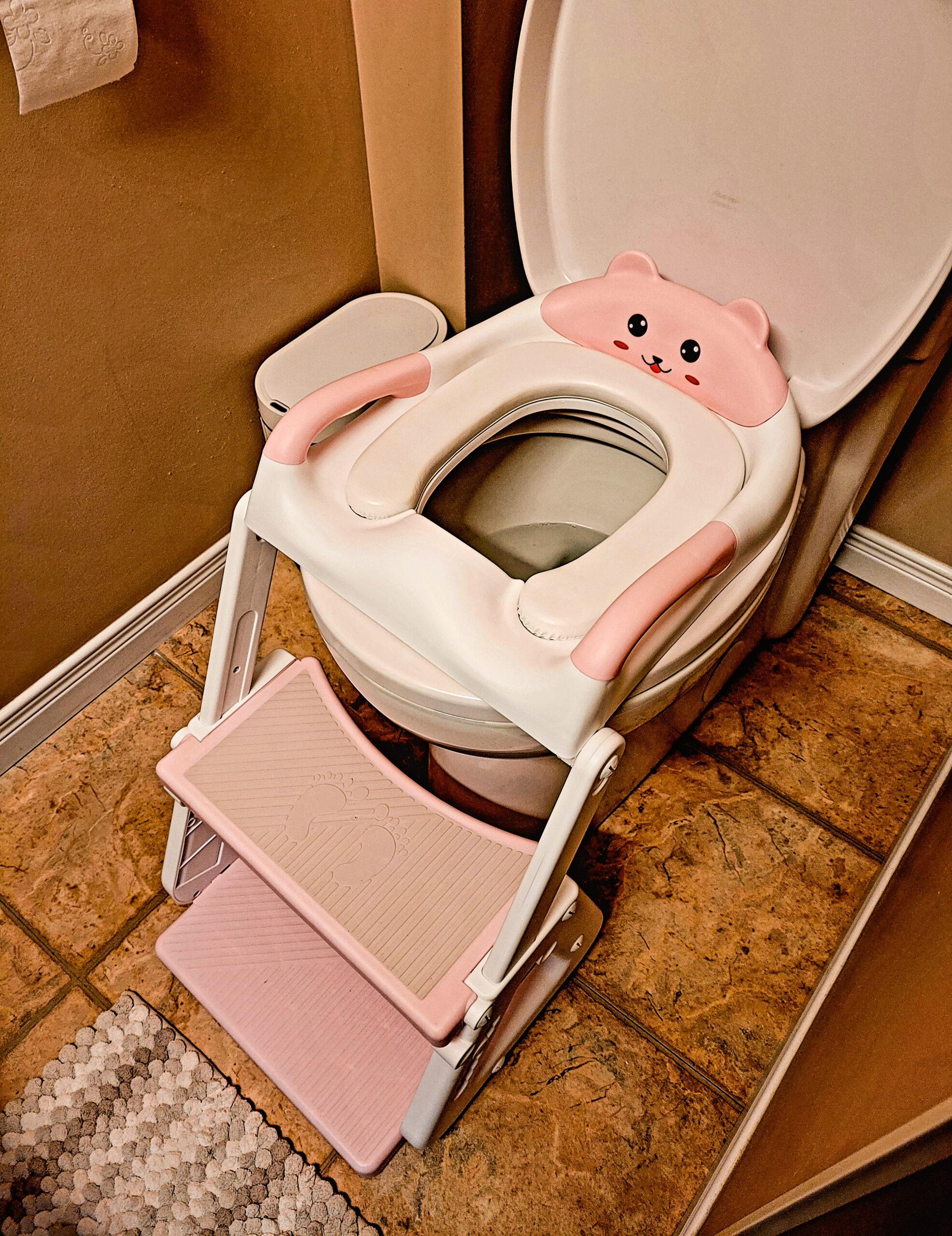 pink and white toddler toilet with teddy bear face